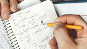 Mano resolviendo ecuaciones trigonométricas a lápiz en un cuaderno de matemáticas.