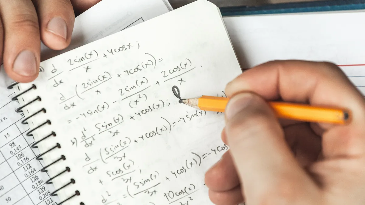 Mano resolviendo ecuaciones trigonométricas a lápiz en un cuaderno de matemáticas.