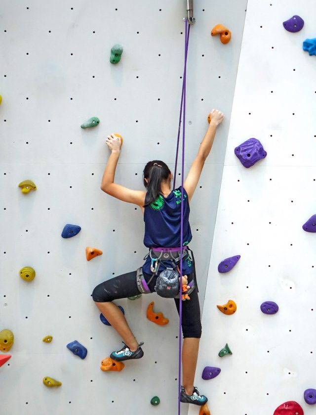 Imagen de portada del Texto del Estudiante de Ciencias Naturales 4° Básico: una niña que escala un muro de escalada con presas de colores