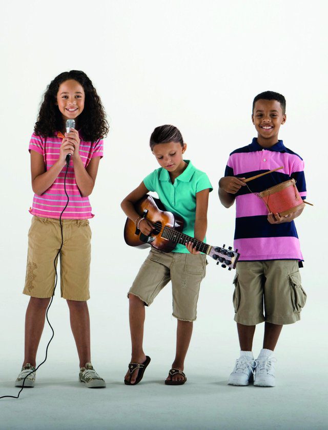 Imagen de portada del Texto del Estudiante de Inglés 6° Básico: tres niños: una cantante con micrófono, un guitarrista y un baterista sobre fondo blanco