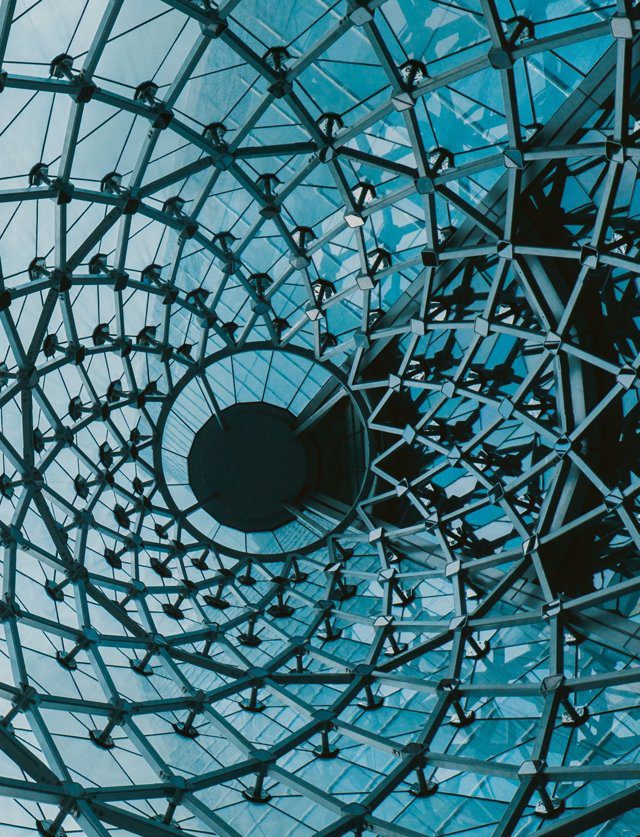 Imagen de portada del Texto del Estudiante de Matemática 2° Medio: una estructura espiral de vidrio y metal vista desde abajo